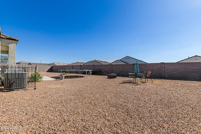 view of yard featuring central AC unit and a trampoline