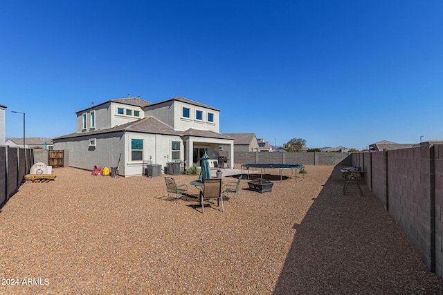 rear view of house with a patio, cooling unit, and a trampoline