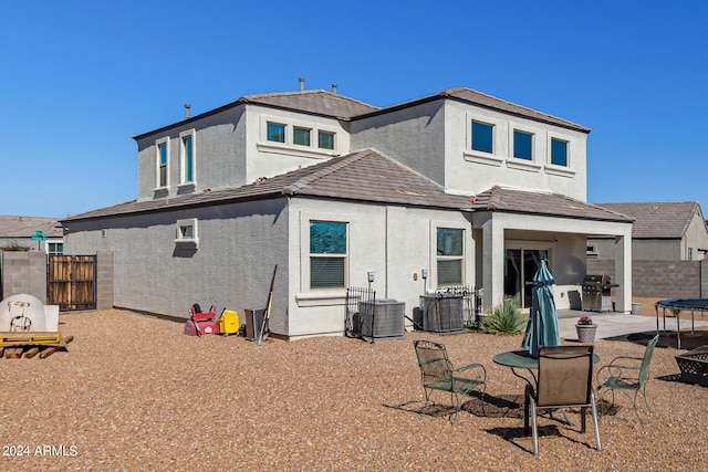 back of house with central air condition unit and a patio