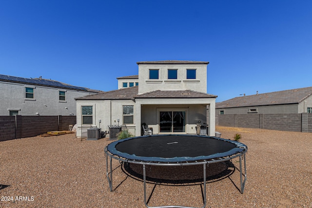 rear view of house with a trampoline and central AC unit