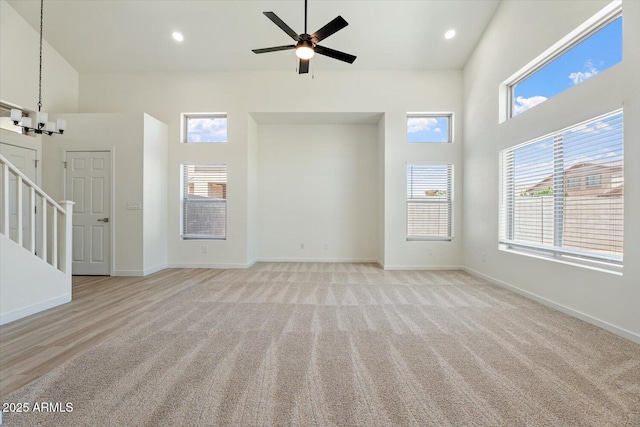 5420 W Grove St, Laveen, AZ 85339 - unfurnished living room with a towering ceiling, stairs, light colored carpet, a ceiling fan, and recessed lighting