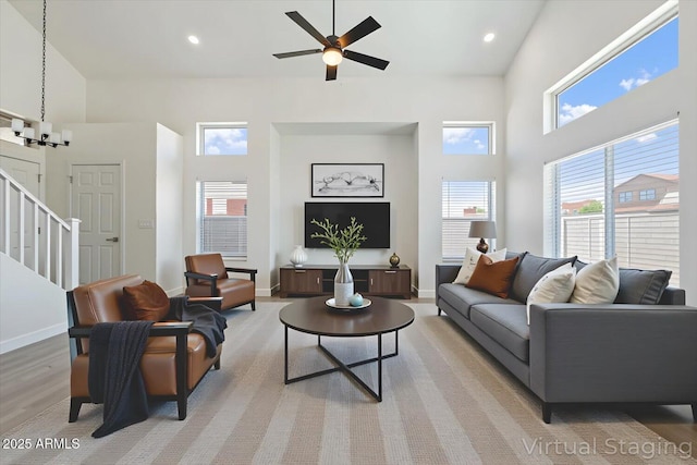 5420 W Grove St, Laveen, AZ 85339 - living room featuring a high ceiling, plenty of natural light, stairs, ceiling fan, and light wood-style flooring