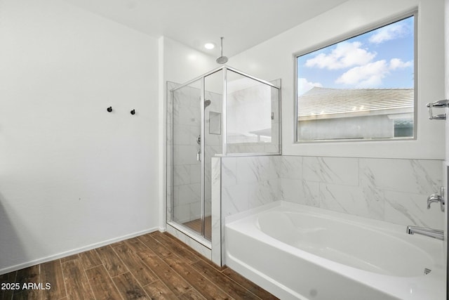full bath with a garden tub, baseboards, a stall shower, and wood finished floors