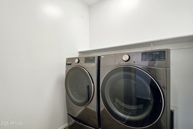 clothes washing area with laundry area, washing machine and dryer, baseboards, and mail area