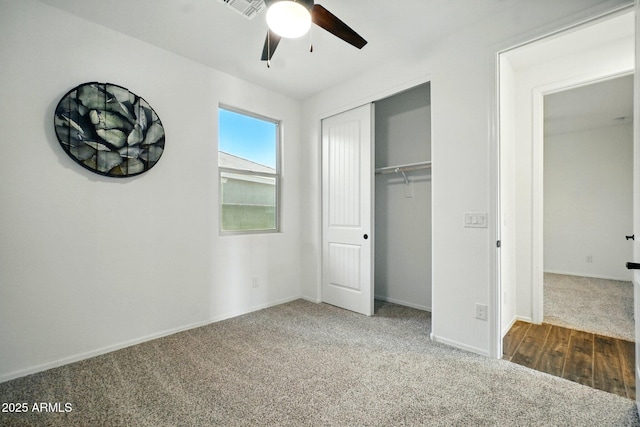 unfurnished bedroom featuring carpet floors, visible vents, a closet, baseboards, and a ceiling fan