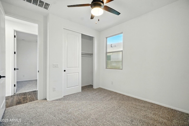 unfurnished bedroom with ceiling fan, visible vents, carpet floors, baseboards, and a closet