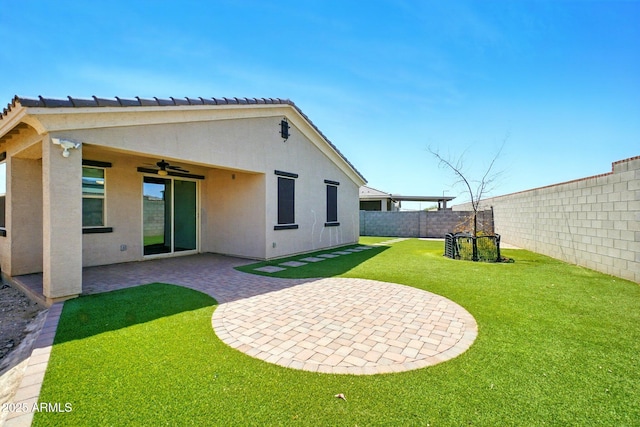 back of property featuring ceiling fan, a lawn, a patio area, a fenced backyard, and stucco siding