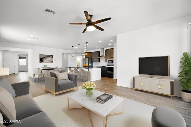 living area featuring a ceiling fan, visible vents, recessed lighting, and light wood-type flooring