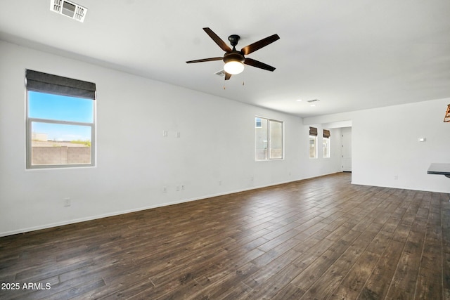 unfurnished living room with visible vents, a ceiling fan, dark wood-style flooring, and baseboards