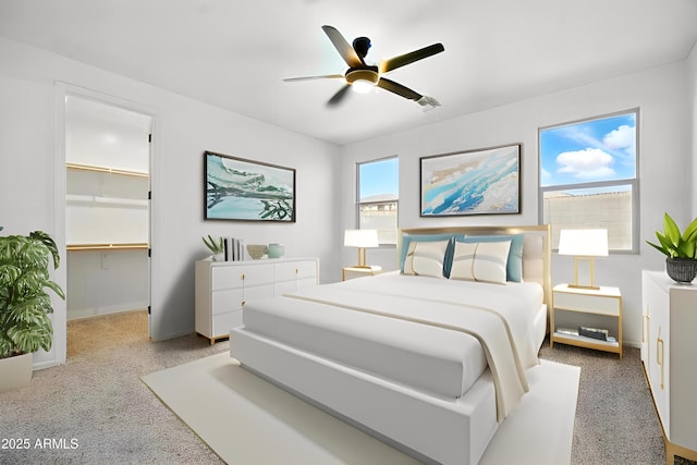 bedroom with a ceiling fan, visible vents, baseboards, a spacious closet, and carpet