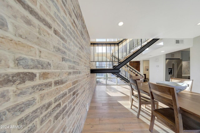 hallway with a healthy amount of sunlight and light hardwood / wood-style floors