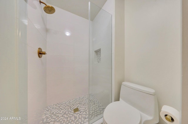 bathroom featuring a tile shower and toilet