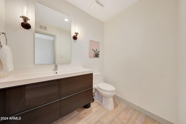 bathroom with vanity, wood-type flooring, and toilet