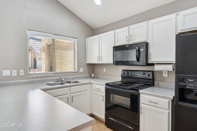 kitchen featuring vaulted ceiling, black appliances, a sink, and white cabinetry