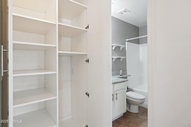 bathroom with visible vents, toilet, tub / shower combination, vanity, and tile patterned floors