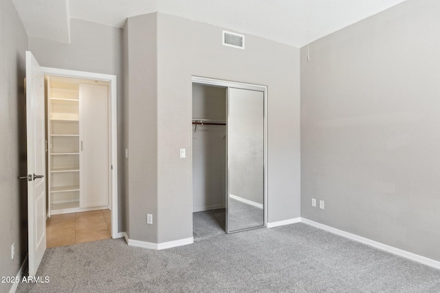 unfurnished bedroom with carpet floors, a closet, visible vents, and baseboards