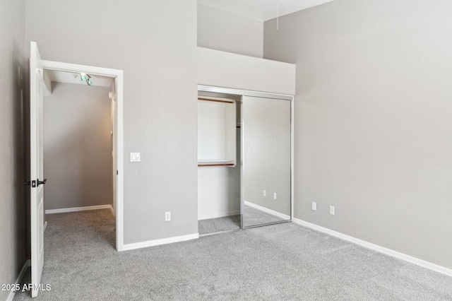 unfurnished bedroom with carpet floors, baseboards, and a closet