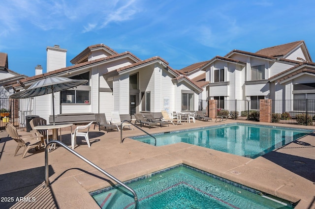 community pool featuring a patio and fence