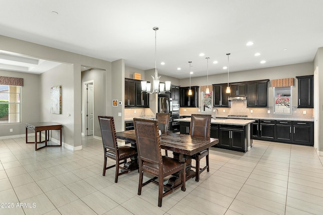 dining space with light tile patterned flooring, sink, and a notable chandelier