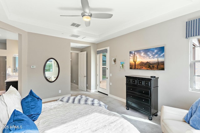 bedroom with ceiling fan, ensuite bathroom, and light carpet