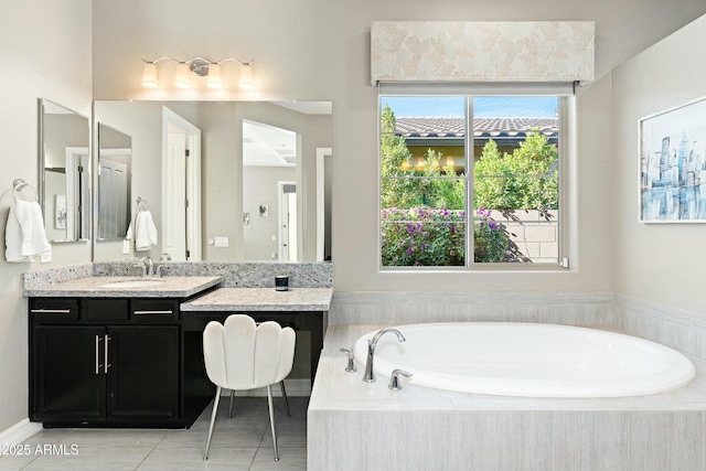 bathroom featuring tiled tub and vanity