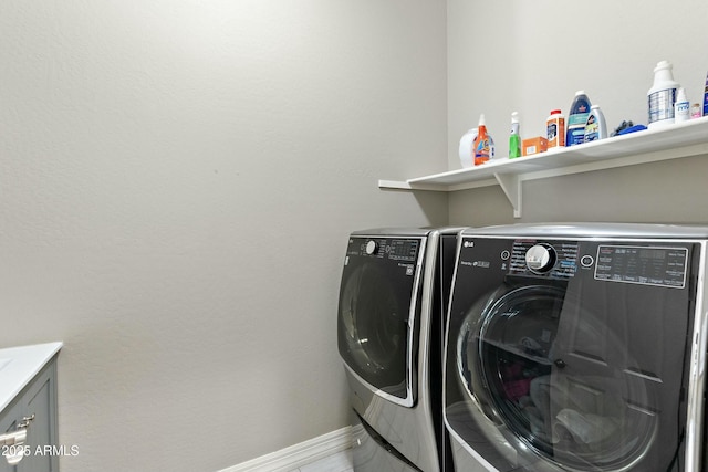 clothes washing area with washing machine and dryer