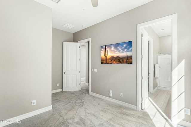 unfurnished bedroom with light carpet, ceiling fan, and ensuite bath