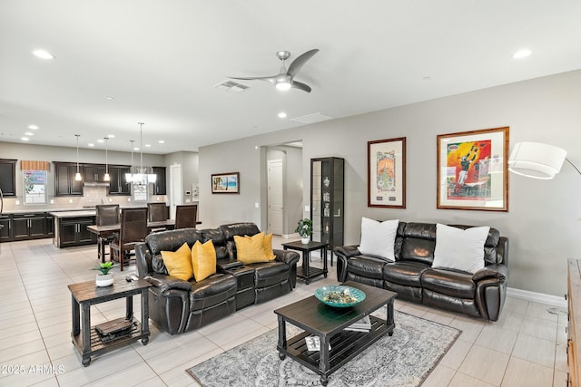 living room featuring light tile patterned floors and ceiling fan with notable chandelier