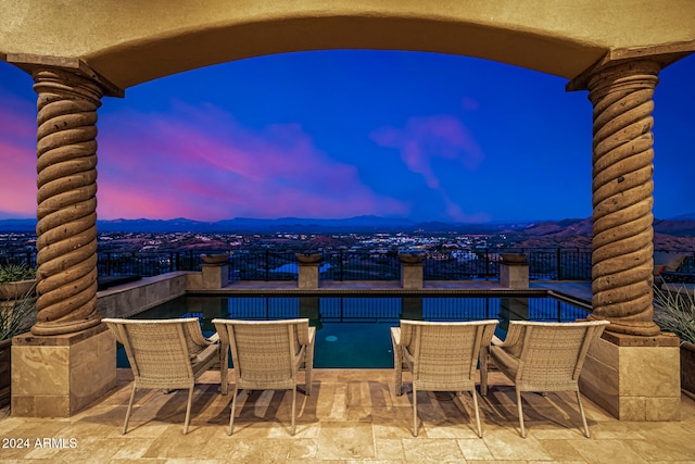 patio terrace at dusk featuring a mountain view