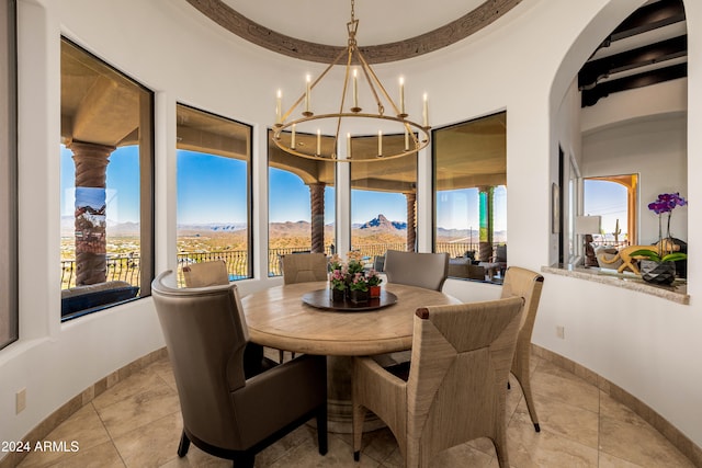 dining area with a mountain view, plenty of natural light, light tile patterned floors, and a chandelier