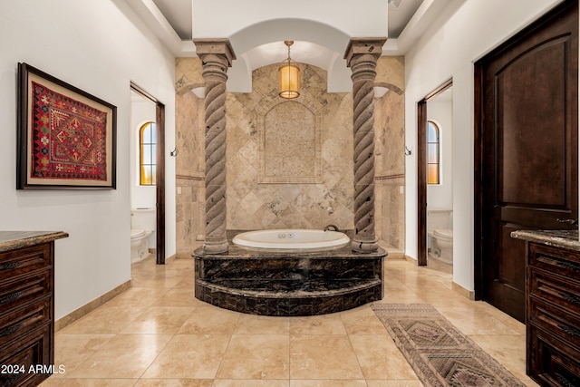 bathroom with tiled bath, ornate columns, tile walls, and toilet