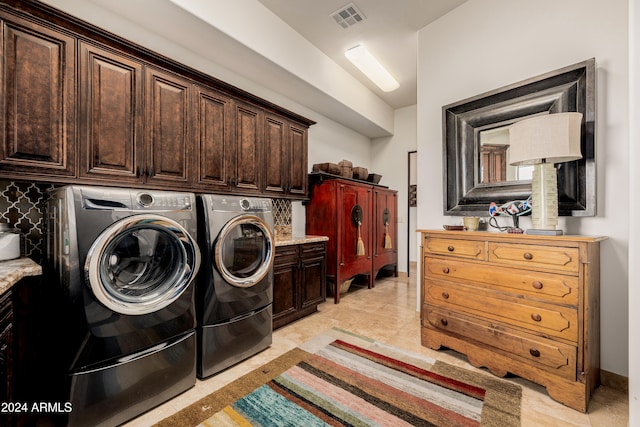 clothes washing area featuring cabinets and washing machine and dryer