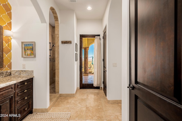 bathroom featuring vanity and tiled shower