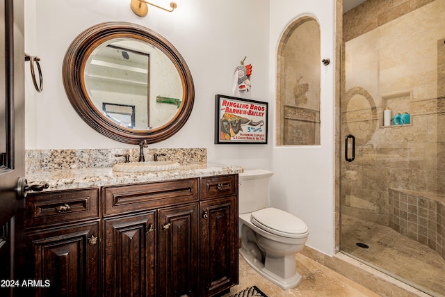 bathroom with tile patterned floors, vanity, a shower with shower door, and toilet