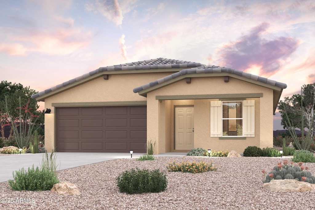 view of front of property featuring a garage, stucco siding, concrete driveway, and a tile roof