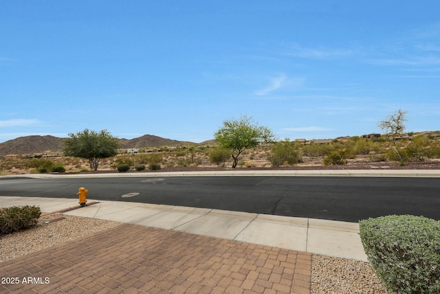 view of street with sidewalks, curbs, and a mountain view
