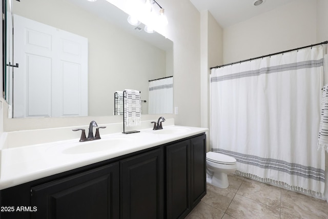 full bath with double vanity, a sink, toilet, and tile patterned flooring