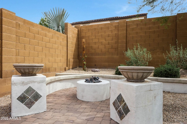 view of patio with fence and a fire pit