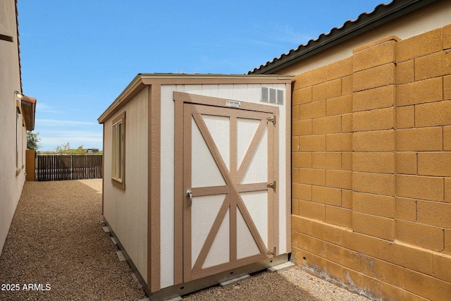 view of shed featuring fence