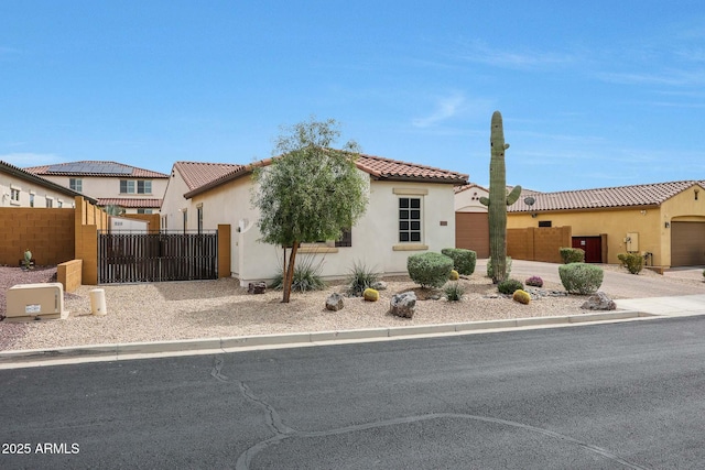 view of front of home featuring a tiled roof, stucco siding, a gate, and fence