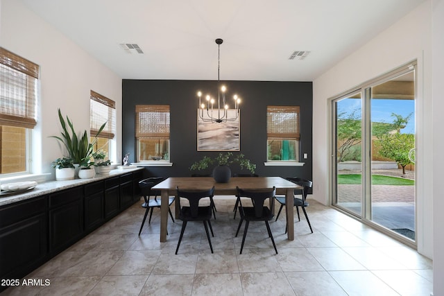 dining area with light tile patterned flooring, a chandelier, and visible vents