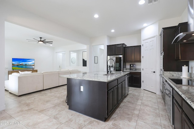 kitchen featuring open floor plan, recessed lighting, a kitchen island with sink, smart refrigerator, and wall chimney exhaust hood