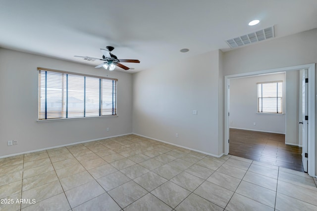 tiled empty room featuring ceiling fan