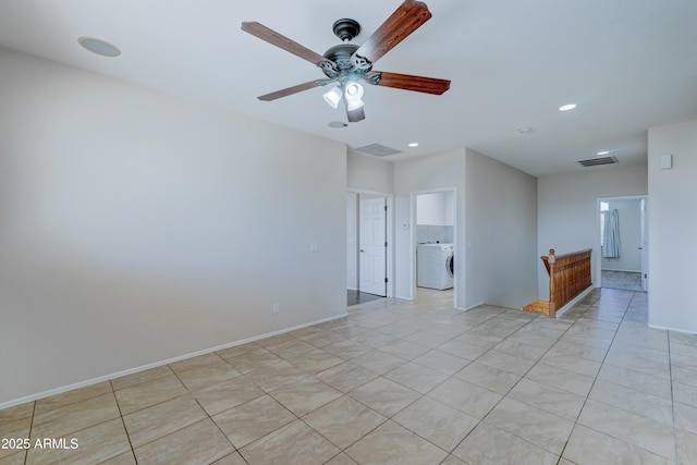 tiled spare room with ceiling fan and washer / clothes dryer