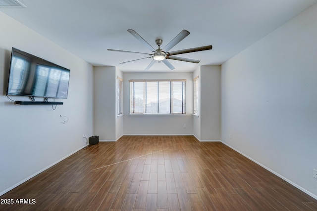 unfurnished room with ceiling fan and dark wood-type flooring