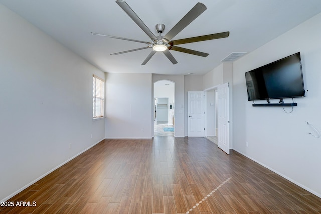 unfurnished living room featuring ceiling fan and dark hardwood / wood-style floors