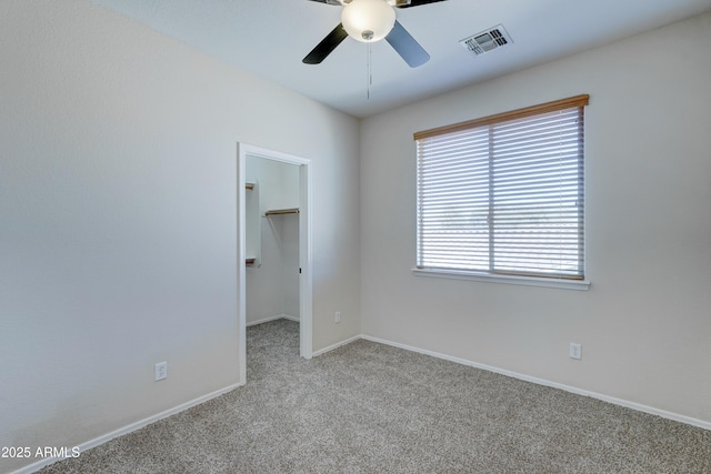 carpeted spare room featuring ceiling fan