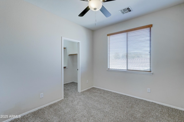 carpeted empty room featuring ceiling fan