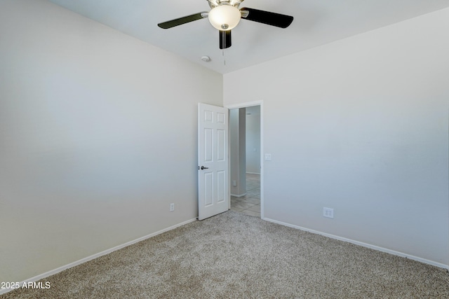 empty room featuring ceiling fan and light colored carpet