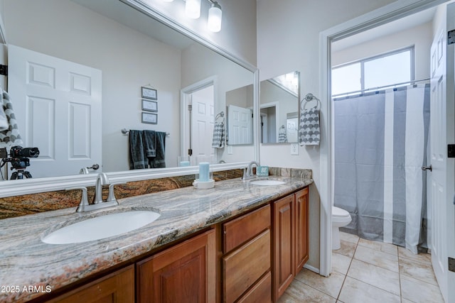 bathroom with toilet, vanity, and tile patterned flooring